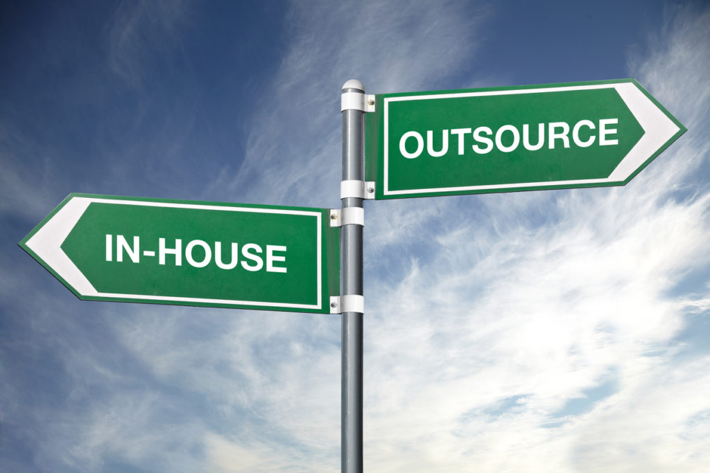 in-house and outsource road signs pointing opposite directions