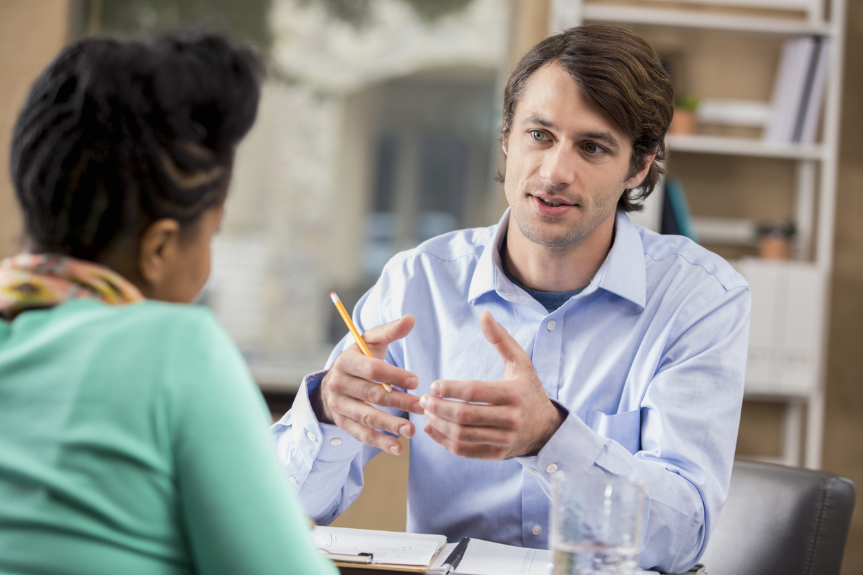 Mid adult businessman interviews prospective female employee