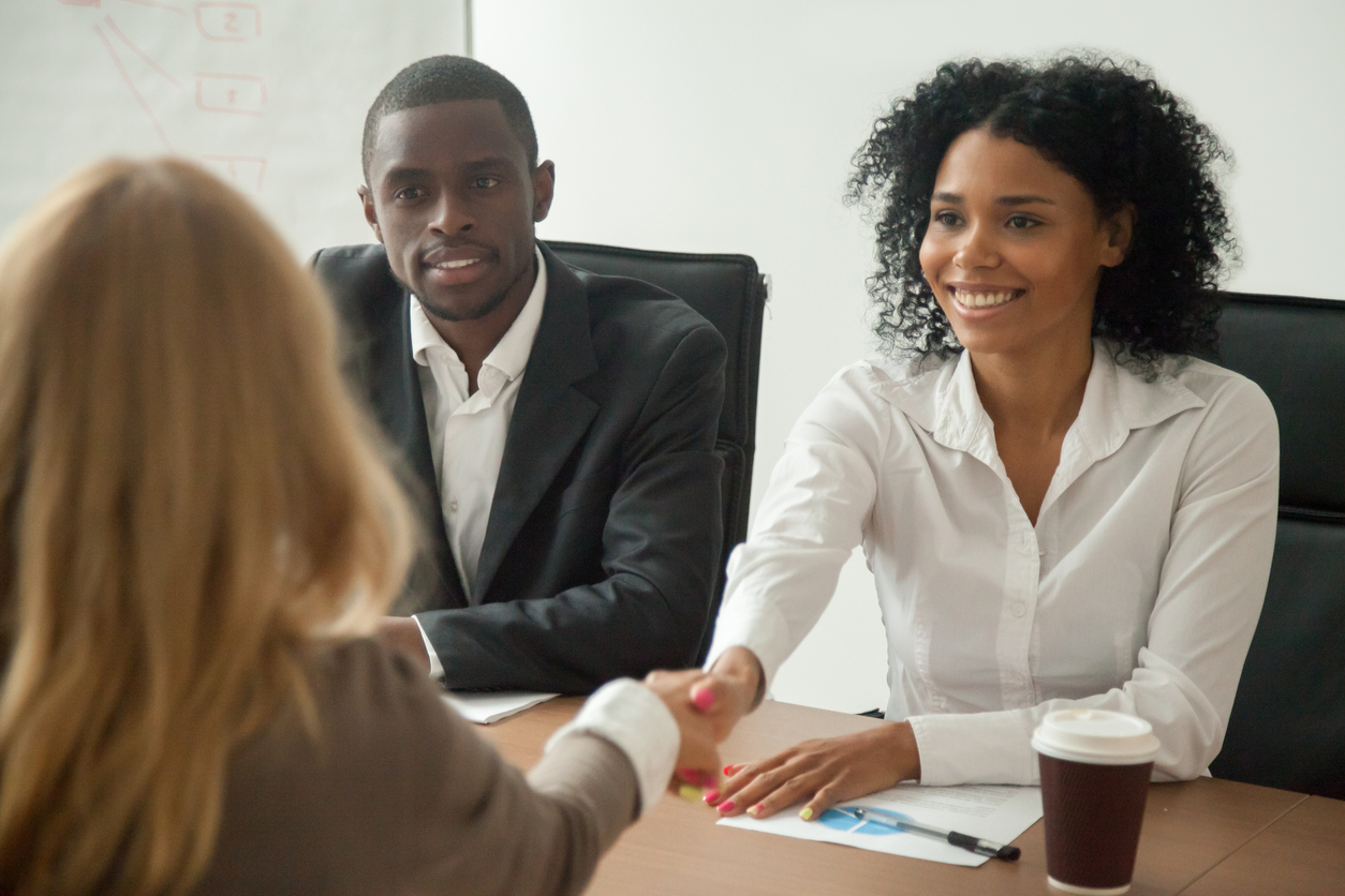 hr team welcoming female applicant at job interview, diverse businesswomen shaking hands at multi ethnic group meeting, handshaking and good first impression, teamwork introduction. temp agency