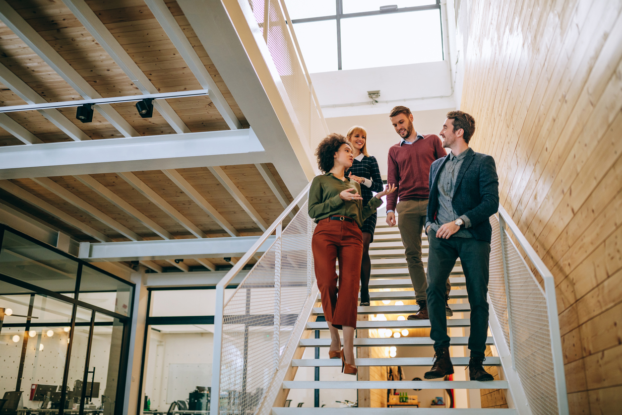 Group of coworkers going down the stairs. Temporary Placements: Benefits of a Temporary Assignment