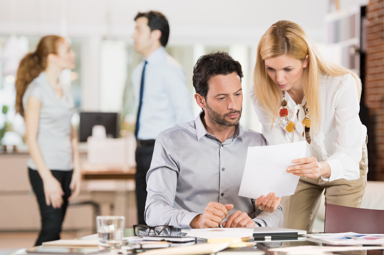 Young businesswoman sharing information with businessman. Young business woman explaining business reports to a coleague. Secretary delivered an accounting certification document to a businessman.