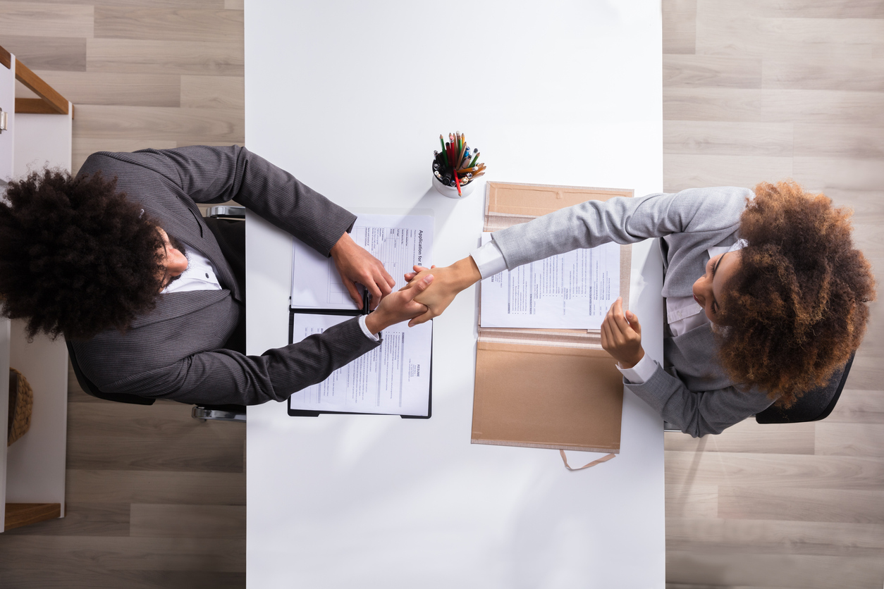 Elevated View Of A Male Manager Shaking Hands With Female Applicant Interviewing For An Accounting Job At Workplace