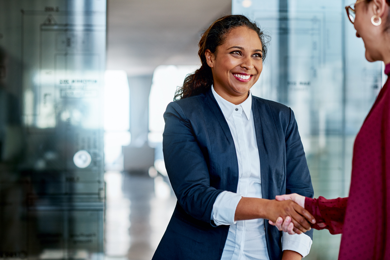 Businesswomen shaking hands with a headhunter in a modern office. Hiring concept