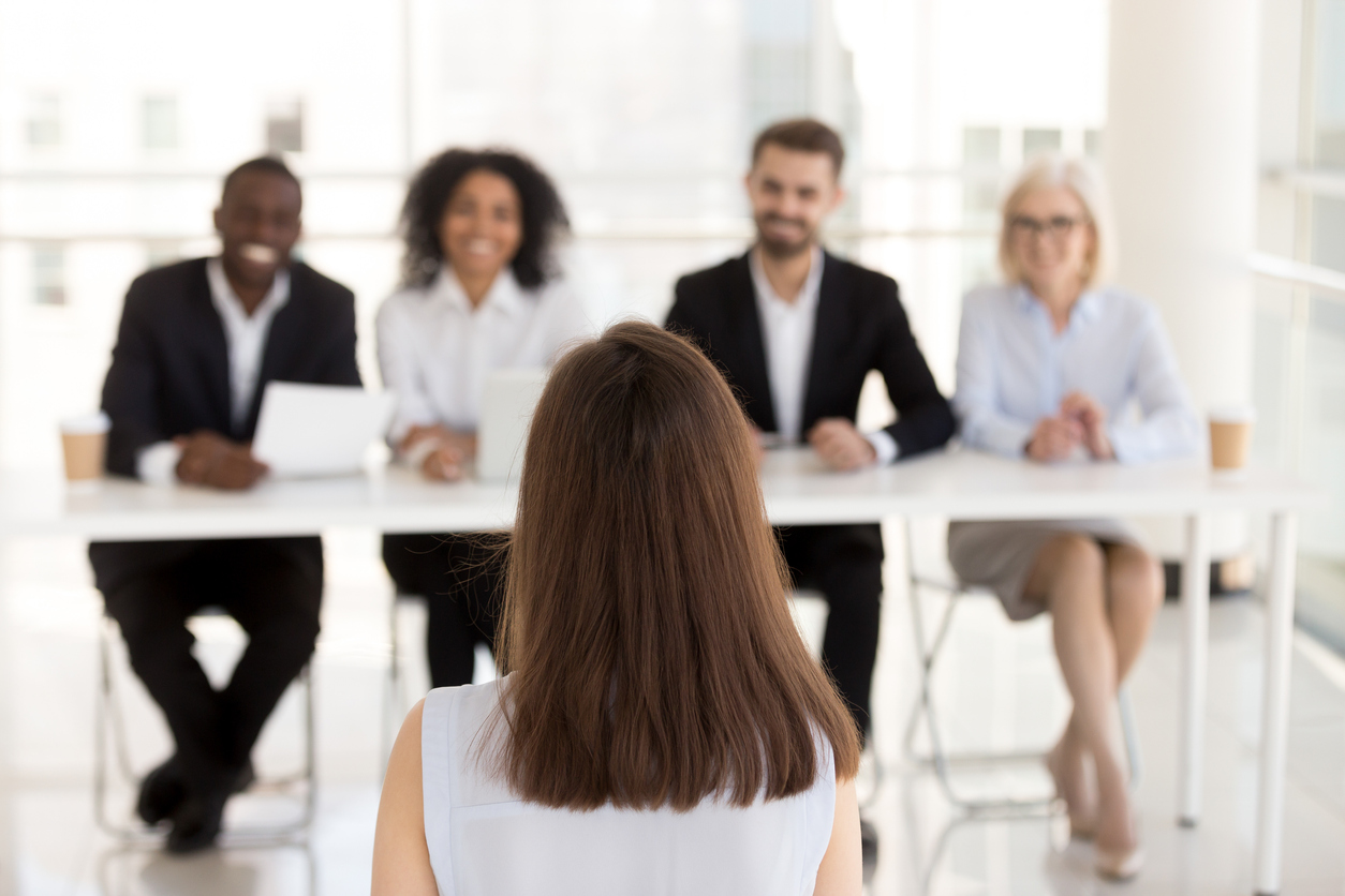 Back view of female job applicant make good first impression at work interview in office, millennial woman candidate talk, impress HR managers or recruiters at hiring. Employment hyper growth concept