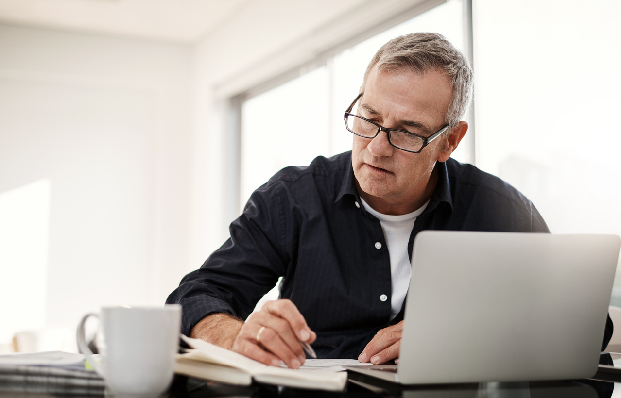 Mature man looking for part-time jobs for seniors on her laptop.