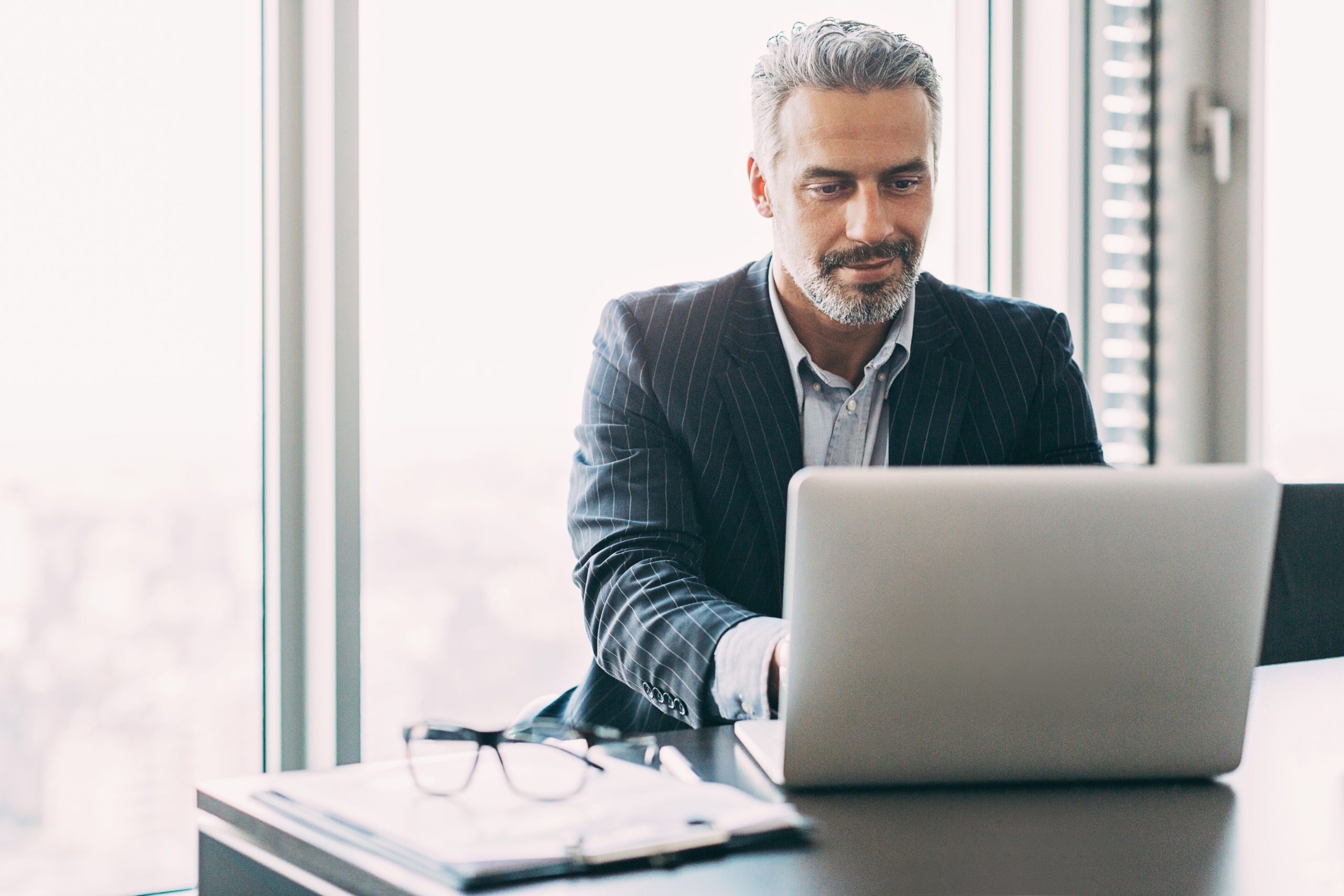 Hiring manager typing on a laptop in his office, making top talent acquisition look easy