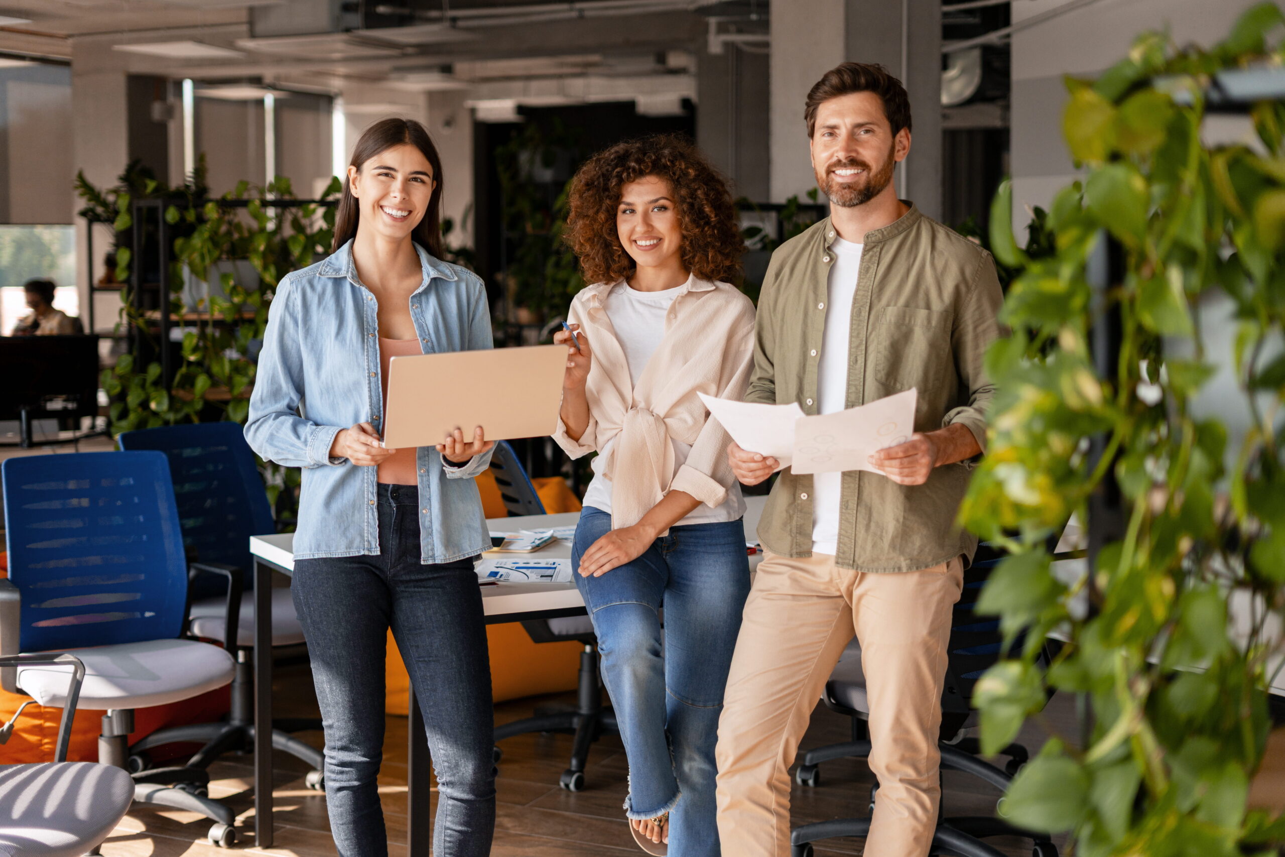 two women and a man holding a paper in an office